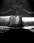 Dracula Peekaboo pillow by Muahaha!  Black and white photo of the 16x16 faux suede pillow showing Dracula's face resting on an antique bed in a victorian mansion.  The perfect gothic, horror gift!